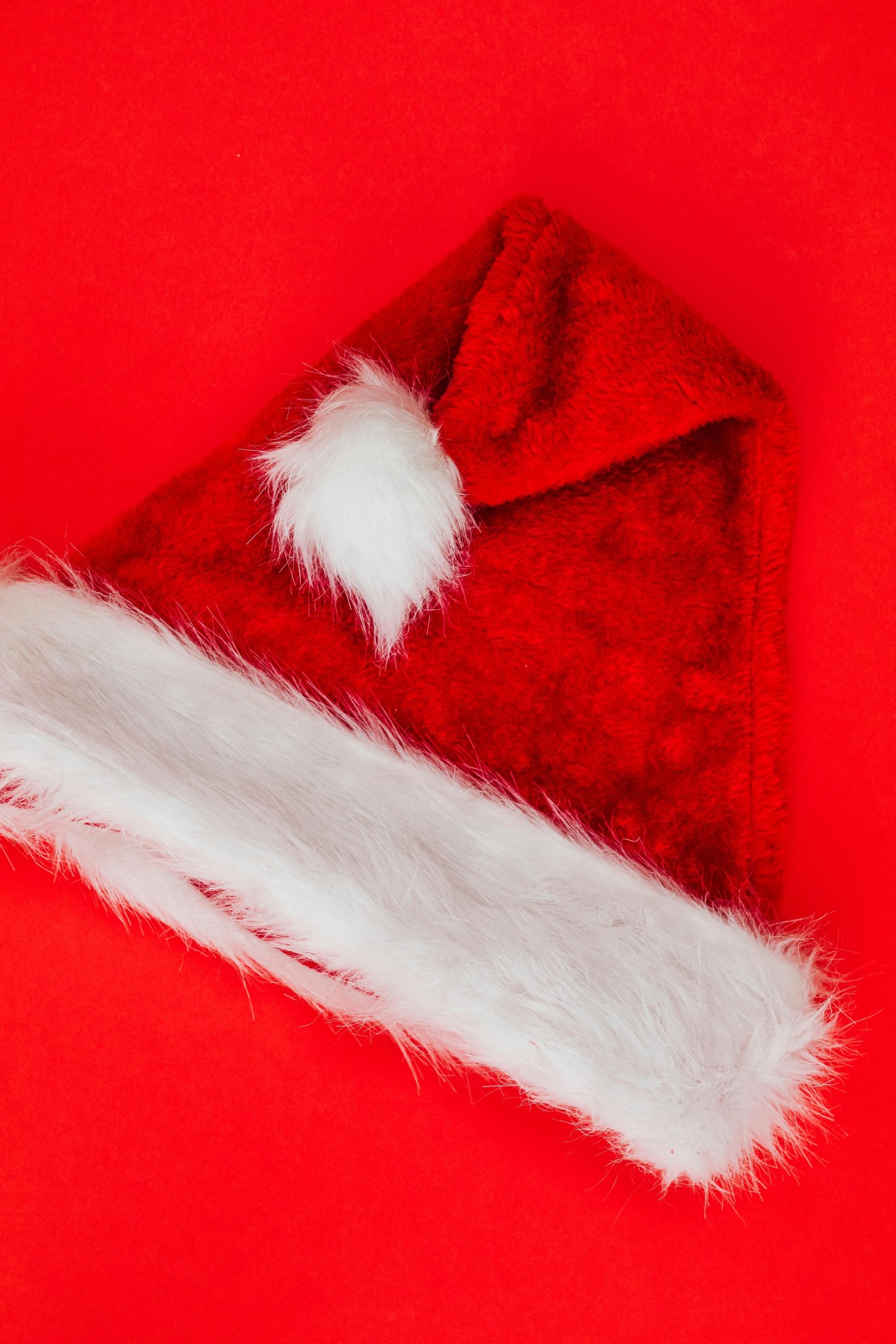 Santa Hat on Red Studio Background / Phot by kaboompics.com via Pexels / Free to use under the Pexels Licence